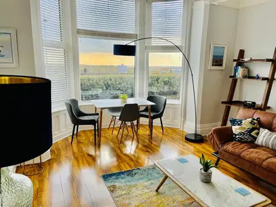 a living room with a table and chairs and a couch at Beach Sunset in Lytham St Annes