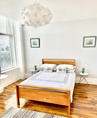 a bedroom with a bed and a chandelier at Beach Sunset in Lytham St Annes