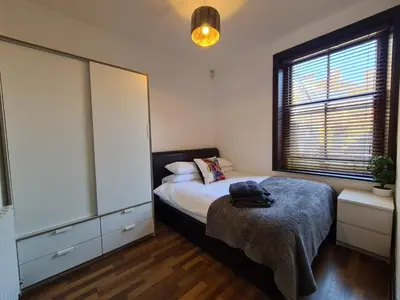 a bedroom with a bed and a dresser and a window at Cube Apartments in Lytham St Annes