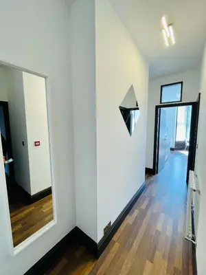 a white room with a mirror and a hallway at Cube Apartments in Lytham St Annes