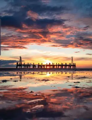 a pier on the beach at sunset at Cube Apartments in Lytham St Annes