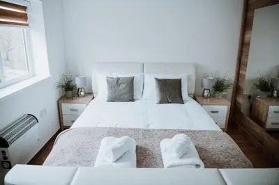 a bedroom with a large white bed with two white towels at Flat 5 Lovely 1-bedroom flat in Liverpool in Liverpool
