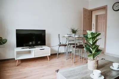a living room with a television and a table with chairs at Flat 5 Lovely 1-bedroom flat in Liverpool in Liverpool