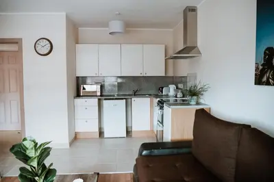 a kitchen with white cabinets and a couch in a room at Flat 5 Lovely 1-bedroom flat in Liverpool in Liverpool