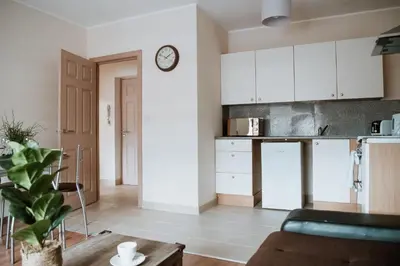 a living room with a couch and a clock on a wall at Flat 5 Lovely 1-bedroom flat in Liverpool in Liverpool