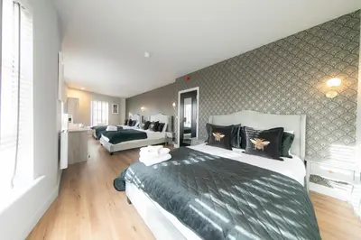 a large bedroom with two beds and a wall at The Old Bank Apartments in Blackpool