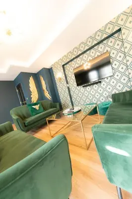 a living room with two green chairs and a table at The Old Bank Apartments in Blackpool