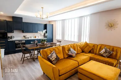 a living room and kitchen with a couch and a table at The Old Bank Apartments in Blackpool