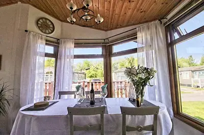 a dining room with a table and a large window at Dot's Place 1 in Carnforth