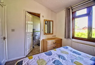 a bedroom with a bed and a window and a mirror at Dot's Place 1 in Carnforth