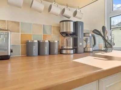 a kitchen counter with a bunch of appliances on it at Beautiful 3 Bed Cottage in the Heart of Flookburgh - Pass the Keys in Grange Over Sands