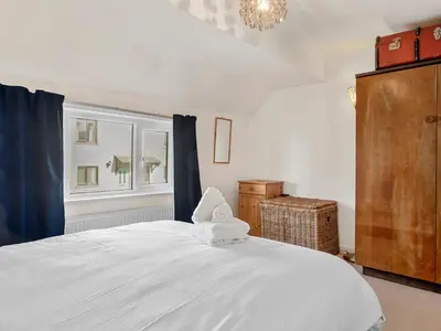 a bedroom with a large white bed and a window at Beautiful 3 Bed Cottage in the Heart of Flookburgh - Pass the Keys in Grange Over Sands