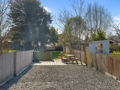 a patio with a wooden fence and a picnic table at Beautiful 3 Bed Cottage in the Heart of Flookburgh - Pass the Keys in Grange Over Sands