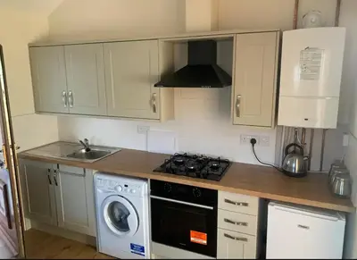a kitchen with a stove top oven next to a sink at Salcombe Holiday Cottage in Wilpshire