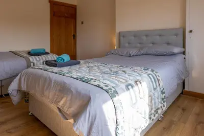a bedroom with two beds with blue towels on them at Abbey Farm House Ormskirk in Ormskirk