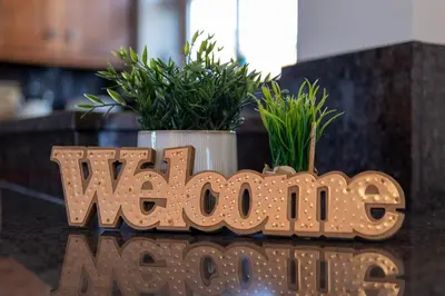 a wooden sign that readswwinylma with two plants at Abbey Farm House Ormskirk in Ormskirk
