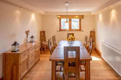 a dining room with a wooden table and chairs at Abbey Farm House Ormskirk in Ormskirk