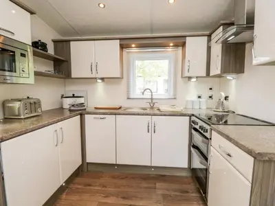 a kitchen with white cabinets and a sink at Number 10 in Carnforth