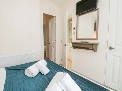 a bedroom with a bed with two pillows and a mirror at Number 10 in Carnforth