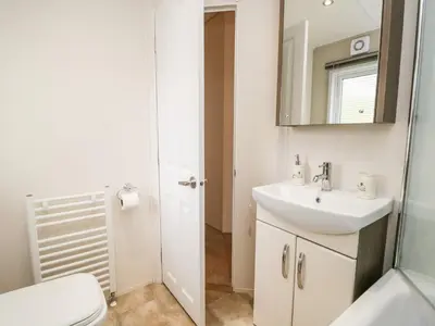 a bathroom with a sink and a toilet and a mirror at Number 10 in Carnforth