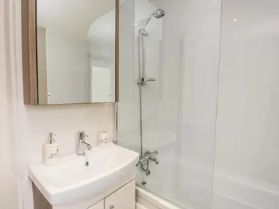 a white bathroom with a sink and a shower at Number 10 in Carnforth