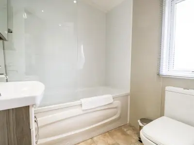 a bathroom with a tub and a toilet and a sink at Number 10 in Carnforth