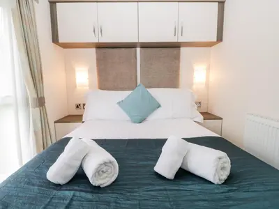 a bedroom with a large bed with towels on it at Number 10 in Carnforth
