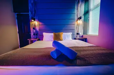 a bedroom with a large bed with a blue object on it at BREEZE BLACKPOOL LUXURY SUITES in Blackpool