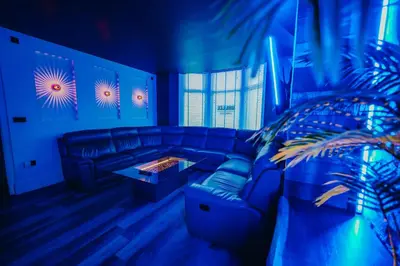 a blue room with a couch and a table at BREEZE BLACKPOOL LUXURY SUITES in Blackpool