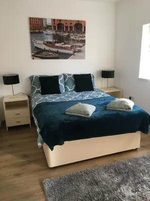 a bedroom with a large bed with a blue blanket at Modern 1 bedroom flat perfect for match or city break in Liverpool