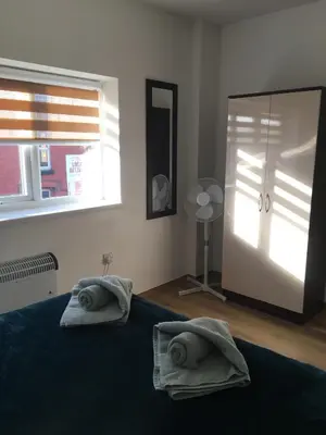 a bedroom with a bed and a mirror and a window at Modern 1 bedroom flat perfect for match or city break in Liverpool