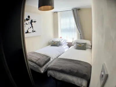 a bedroom with two beds and a mirror at Winter Gardens North Pier 2 Bed in Blackpool