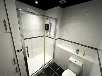 a white bathroom with a shower and a toilet at Winter Gardens North Pier 2 Bed in Blackpool