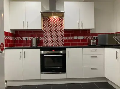 a kitchen with white cabinets and a black oven at Winter Gardens North Pier 2 Bed in Blackpool