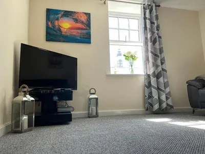 a living room with a flat screen tv and a window at Winter Gardens North Pier 2 Bed in Blackpool