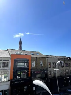 a group of buildings with a clock tower in the background at Winter Gardens North Pier 2 Bed in Blackpool