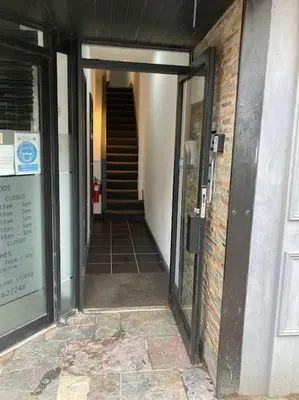 a hallway leading to a building with a stair case at Winter Gardens North Pier 2 Bed in Blackpool