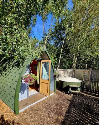 a small green tent with a door in a yard at The Forest Pod - Wood Fired Hot Tub and Fire Pit in Hambleton