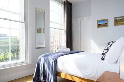a white bedroom with a bed and a window at Seymour Townhouse by Serviced Living Liverpool in Liverpool