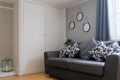 a living room with a couch and mirrors on the wall at Seymour Townhouse by Serviced Living Liverpool in Liverpool