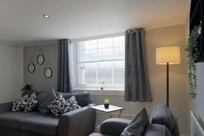 a living room with a couch and a window at Seymour Townhouse by Serviced Living Liverpool in Liverpool