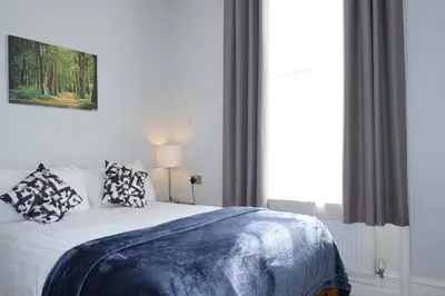 a bedroom with a bed with pillows on it at Seymour Townhouse by Serviced Living Liverpool in Liverpool