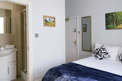 a white bedroom with a bed and a sink at Seymour Townhouse by Serviced Living Liverpool in Liverpool