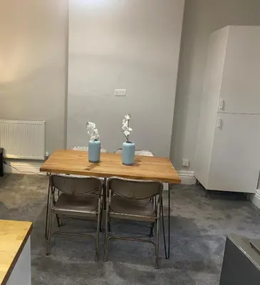 a wooden table with two chairs and two vases on it at 1 bedroom spacious apartment in Lytham St Annes