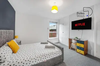 a bedroom with a bed and a tv on a wall at PolkaDot Winter Gardens - Large Modern Apartments in Blackpool by PolkaStays in Blackpool