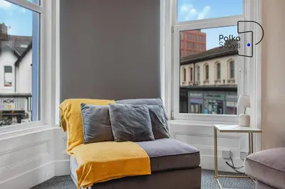 a living room with a chair and a window at PolkaDot Winter Gardens - Large Modern Apartments in Blackpool by PolkaStays in Blackpool