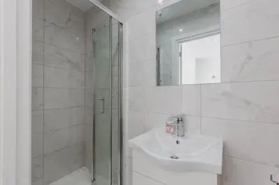 a white bathroom with a sink and a shower at RST Luxury Aparthotel in Liverpool
