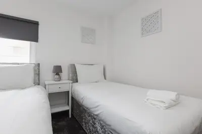 a bedroom with two beds and a night stand at RST Luxury Aparthotel in Liverpool