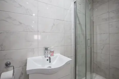 a white bathroom with a sink and a shower at RST Luxury Aparthotel in Liverpool