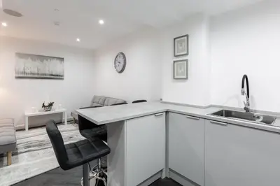 a white kitchen with a counter and a sink at RST Luxury Aparthotel in Liverpool